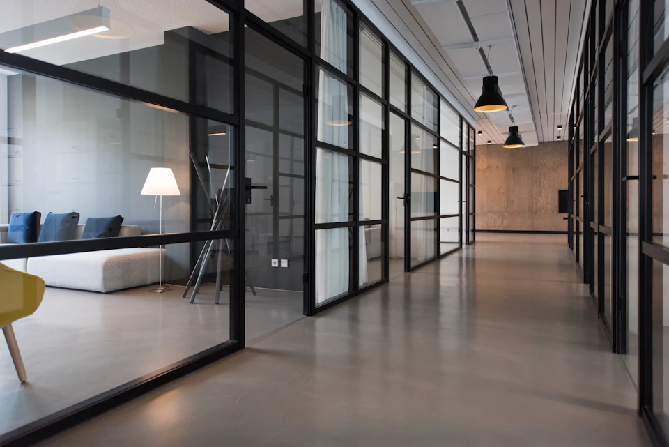 A modern glass-walled office corridor